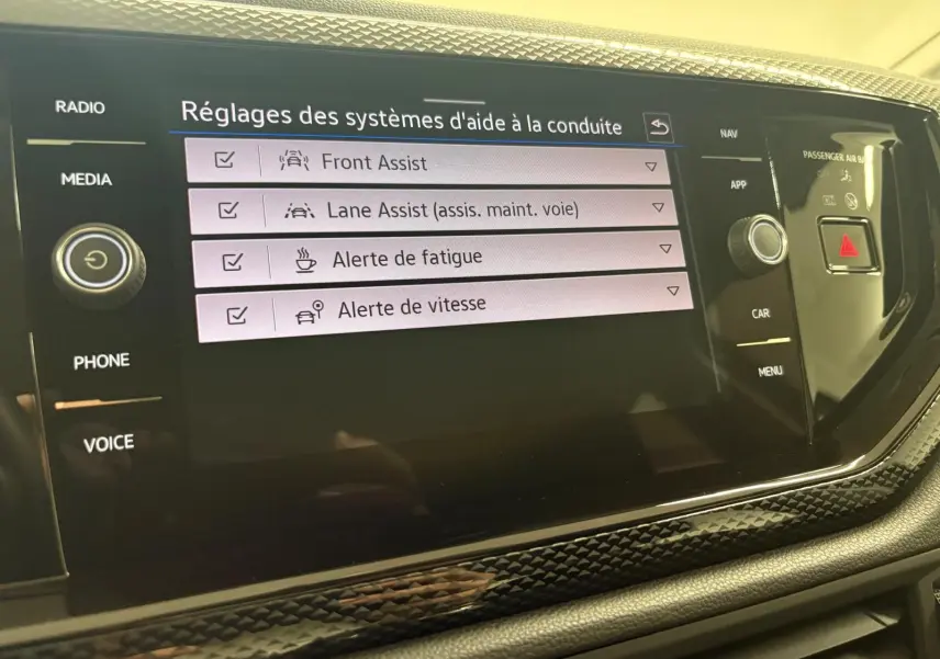 Écran central tactile de la Volkswagen Polo gris cendre 2024 affichant les réglages d’aide à la conduite.