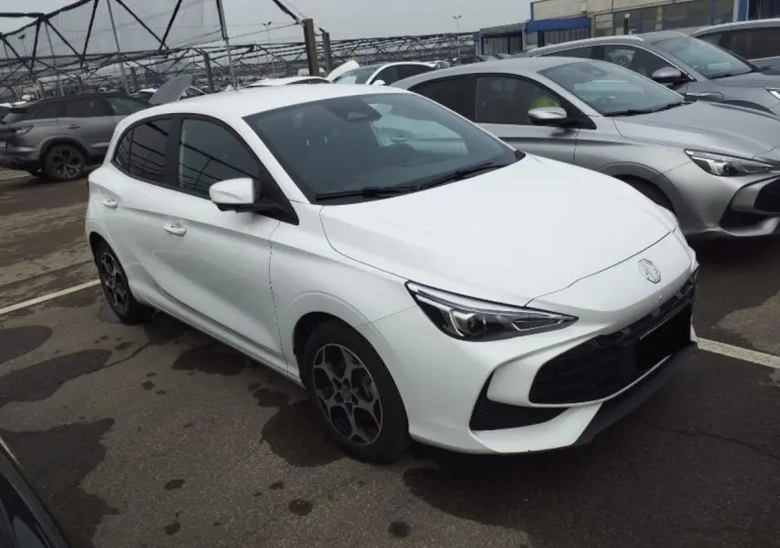 MG3 1.5 Hybrid+ 195 Luxury blanc Dover en 3/4 avant droit, avec jantes alliage et calandre noire distinctive.