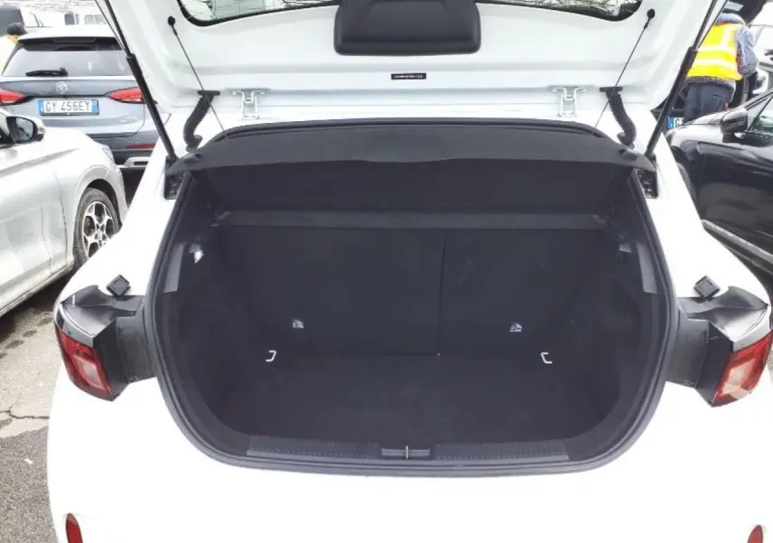 Coffre ouvert vu de l'arrière d'une MG3 1.5 Hybrid+ 195 Luxury blanc Dover, intérieur noir spacieux et vide.