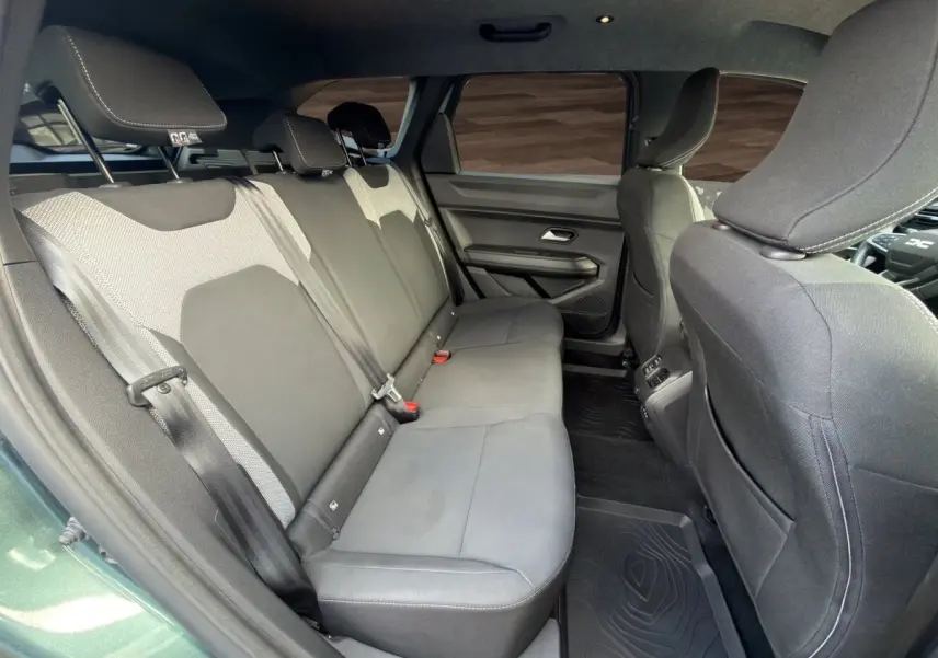 Vue intérieure côté gauche montrant la banquette arrière grise du Dacia Bigster Journey Hybrid 2025 vert.
