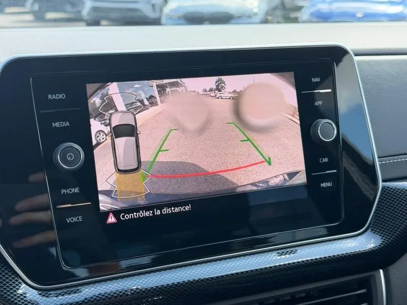 Écran tactile intérieur affichant la caméra de recul du Volkswagen T-Cross jaune, vue arrière avec guidage de trajectoire.