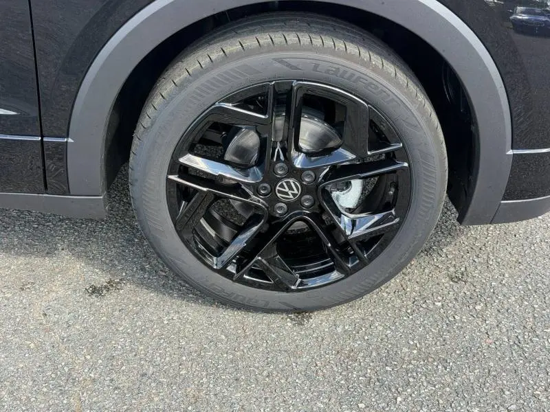 Gros plan sur la jante noire brillante d’un Volkswagen T-Cross 1.0 TSI 116ch R-Line, pneu Laufrad visible.
