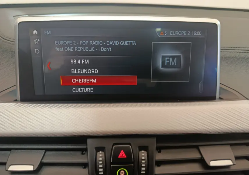 Écran tactile central affichant les stations radio dans l'habitacle d'une BMW X1 sDrive18i M Sport 2019.