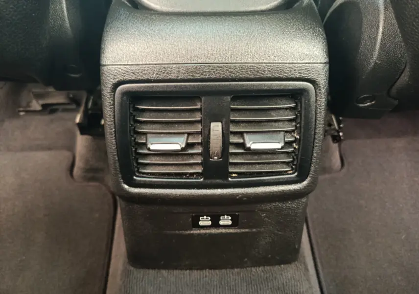 Bouches d'aération arrière noires avec deux ports USB visibles dans l'habitacle d'une BMW X1 sDrive18i M Sport 2019.