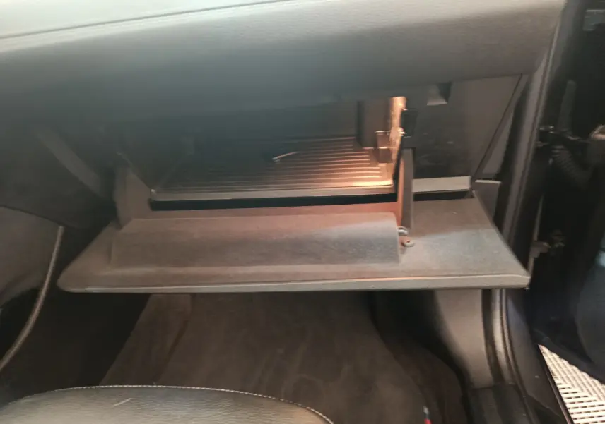 Gant de boîte à gants ouvert côté passager dans l'habitacle sombre d'un BMW X1 sDrive18i M Sport 2019