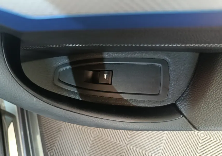 Bouton de commande de lève-vitre côté conducteur sur la portière intérieure noire d'une BMW X1 sDrive18i M Sport 2019.