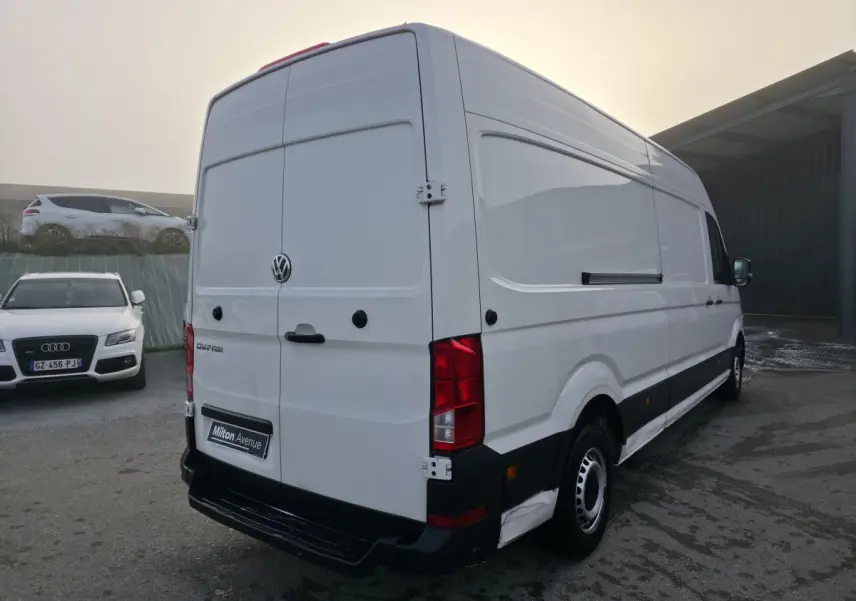 Vue 3/4 arrière droite d'un utilitaire Volkswagen Crafter blanc avec portes arrière fermées et jantes acier.