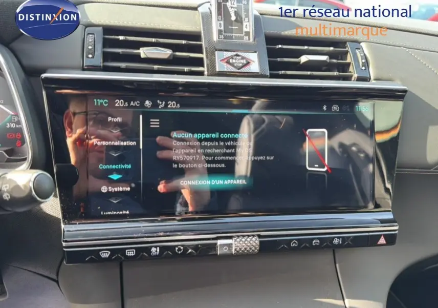 Vue rapprochée de l’écran tactile central et de la console d’une DS7 noire perle 2024, affichant les options de connectivité.