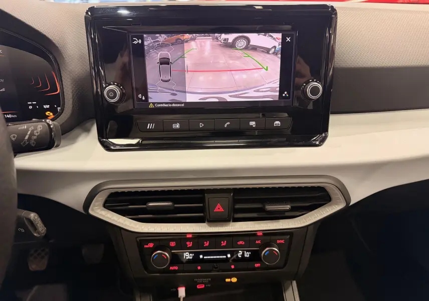 Vue intérieure du tableau de bord de la SEAT Ibiza 2025 avec écran tactile affichant la caméra de recul et commandes de climatisation.