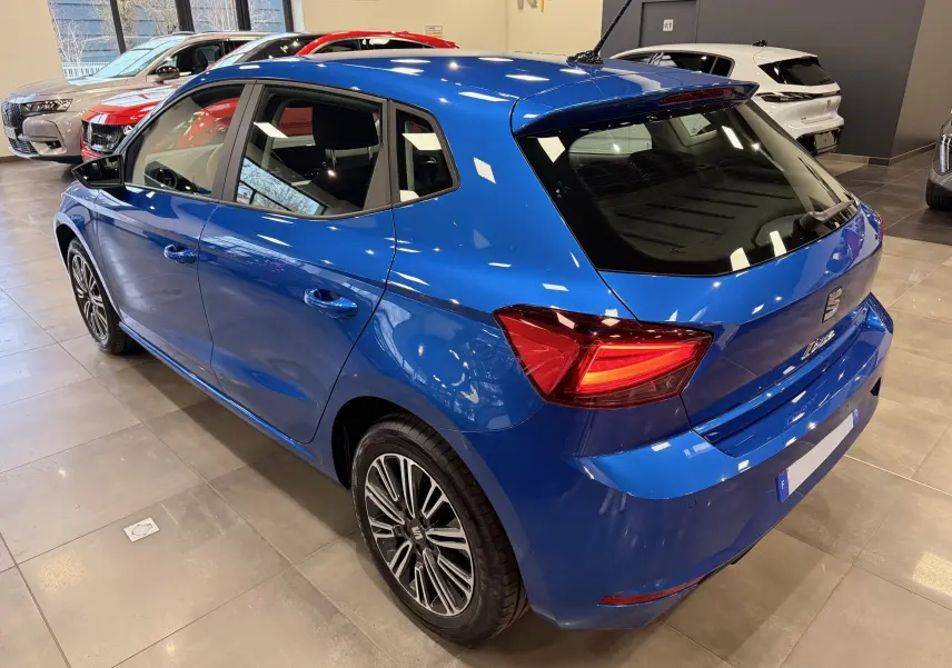 Vue 3/4 arrière droite d'une SEAT Ibiza 1.0 TSI Copa bleu vif avec feux LED et jantes alliage en concession.