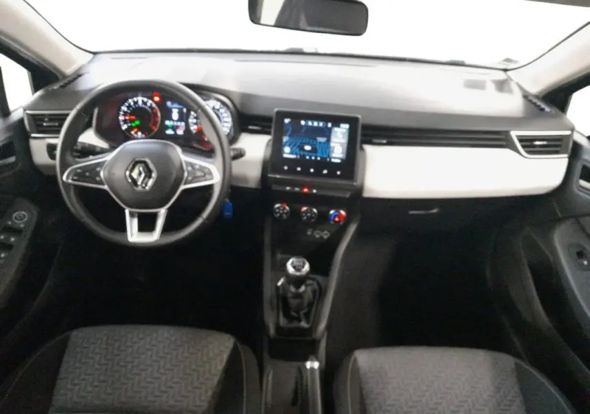 Vue intérieure avant de la Renault Clio 2023 gris clair, avec tableau de bord moderne et boîte manuelle visible.