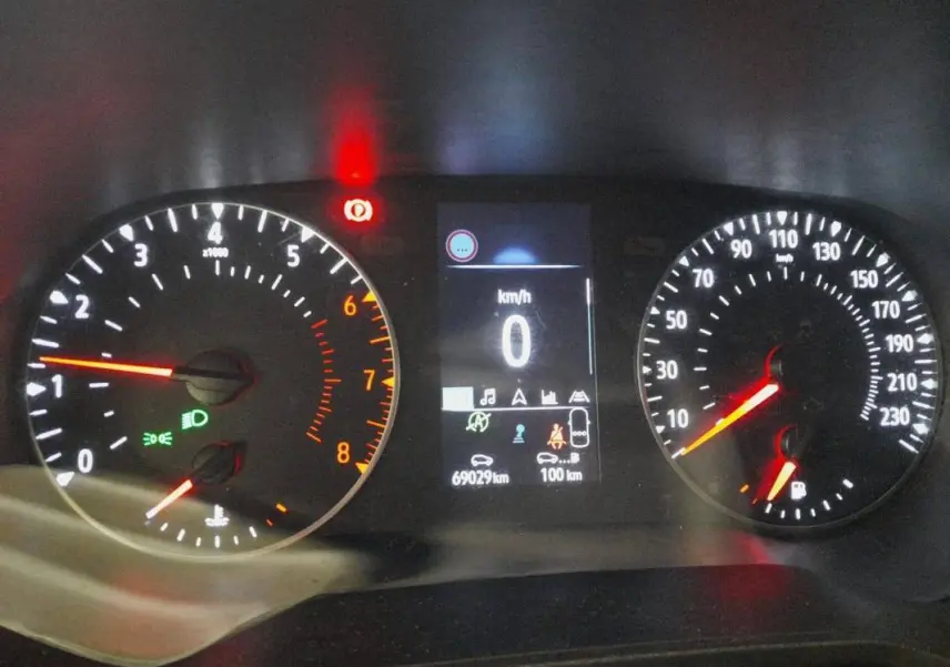 Tableau de bord de Renault Clio gris clair 2023, affichage numérique au centre avec compte-tours et compteur de vitesse analogiques.