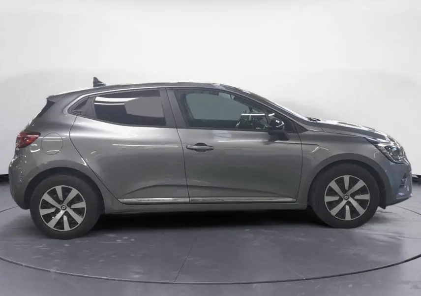 Vue de profil côté gauche d'une Renault Clio gris clair 2023 avec jantes alliage 16 pouces et roue de secours visible.