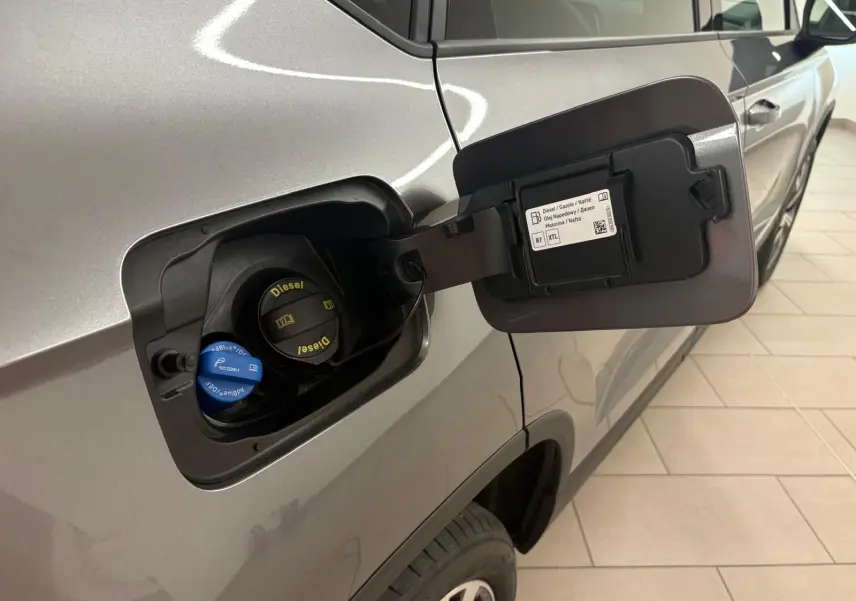 Gros plan sur la trappe à carburant ouverte côté gauche d’un SEAT Ateca gris graphite avec bouchons Diesel et AdBlue visibles.