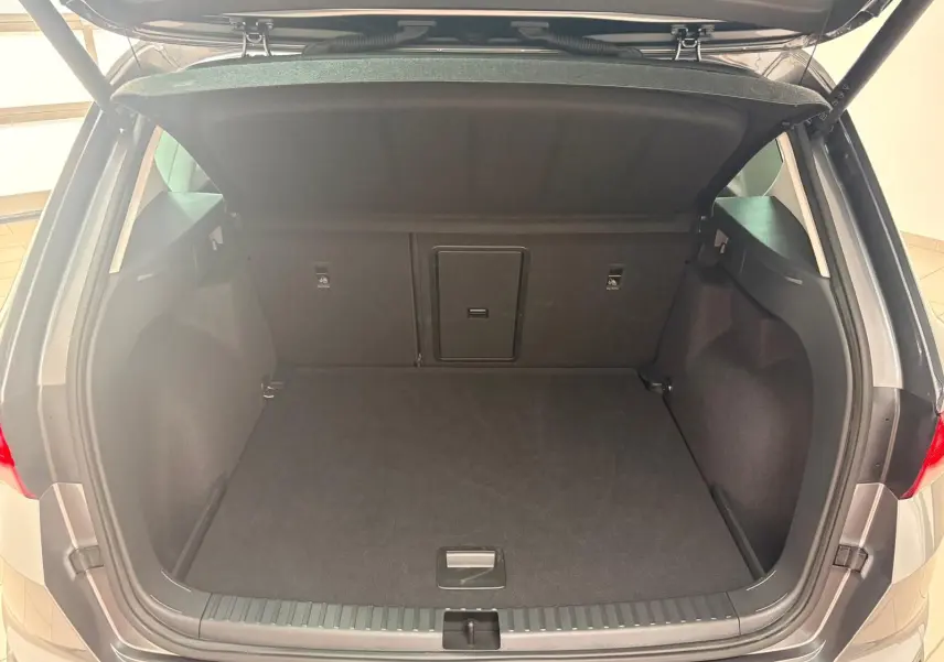 Coffre ouvert vu de l'arrière d'un SEAT Ateca 2.0 TDI Gris Graphite avec hayon électrique mains-libres.