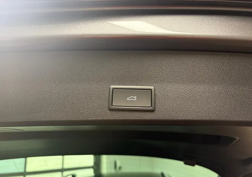 Bouton d'ouverture électrique du hayon sur la partie intérieure du coffre du SEAT Ateca gris graphite, vue rapprochée.