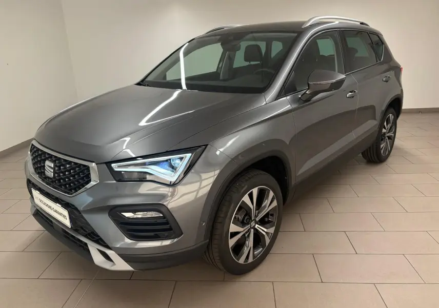 Vue 3/4 avant droit du SEAT Ateca 2025 gris graphite avec jantes alliage 18 pouces et hayon électrique mains-libres.