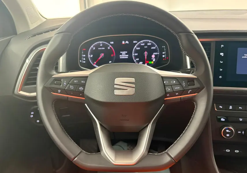 Vue rapprochée du volant noir du SEAT Ateca 2.0 TDI 150 DSG7 Copa avec tableau de bord numérique allumé.