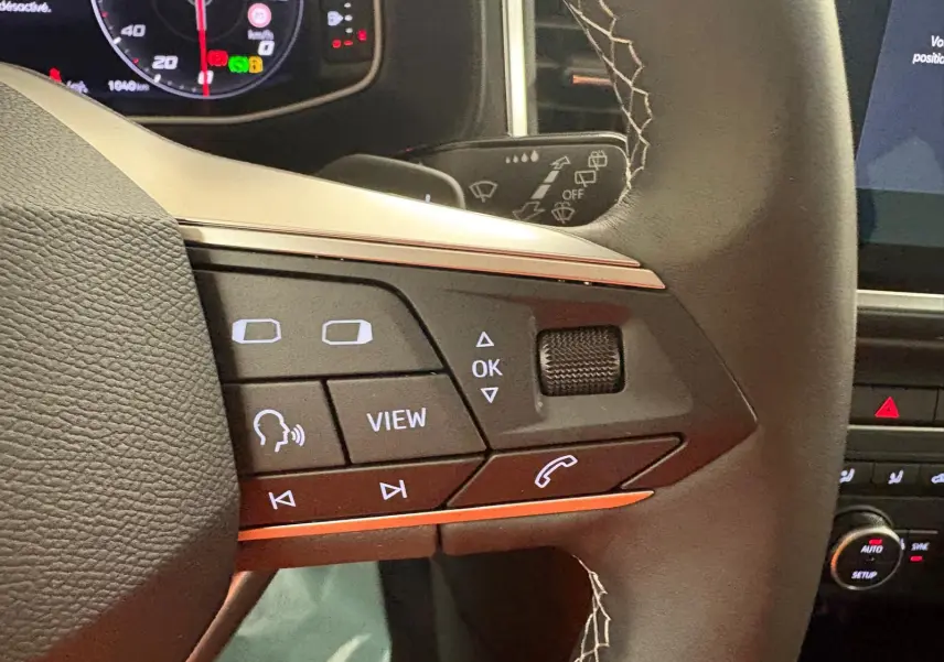 Gros plan sur les commandes multifonctions du volant du SEAT Ateca 2.0 TDI 150 DSG7 COPA, intérieur noir.