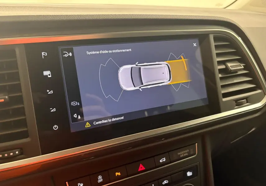 Écran intérieur montrant le système d'aide au stationnement du SEAT Ateca gris graphite, vue de dessus virtuelle du véhicule.