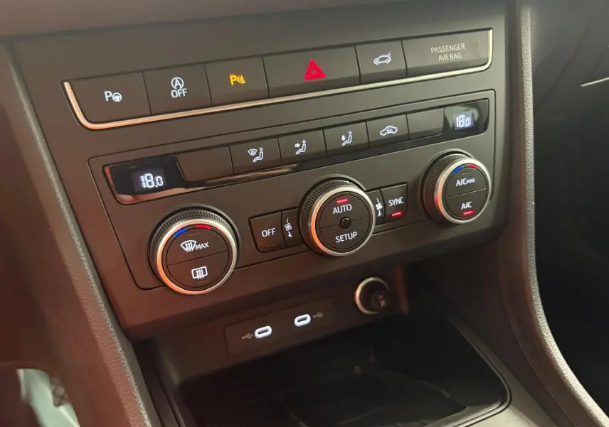 Vue rapprochée du tableau de bord noir du SEAT Ateca 2025, montrant les commandes de climatisation digitales.