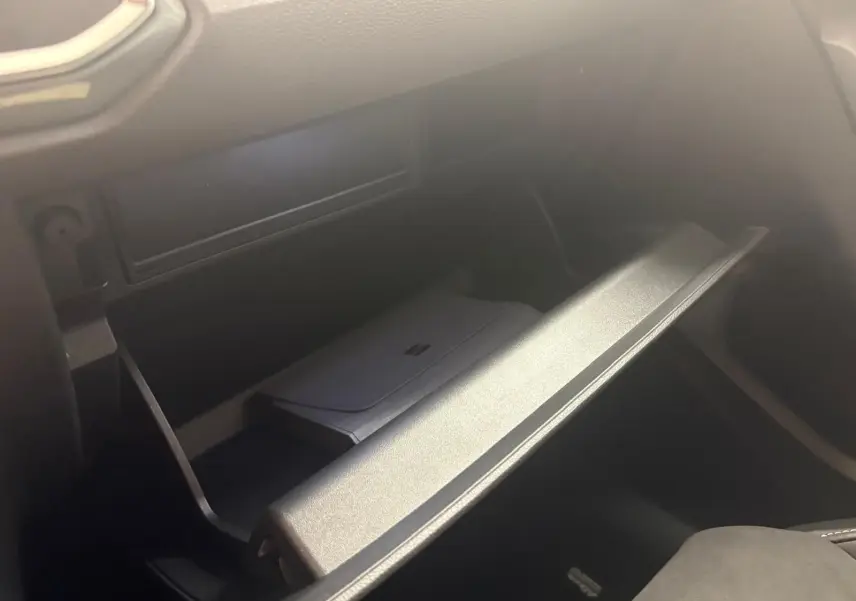 Gros plan sur la boîte à gants ouverte du SEAT Ateca 2.0 TDI 150 DSG7 COPA, intérieur noir.