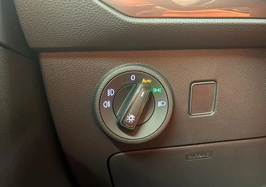 Gros plan sur la molette de réglage des phares dans l’habitacle du SEAT Ateca gris graphite, version 2025.