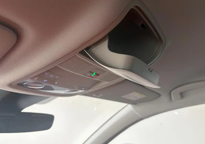 Détail du plafond intérieur du SEAT Ateca 2025 avec rangement lunettes ouvert et commandes éclairage intégrées.