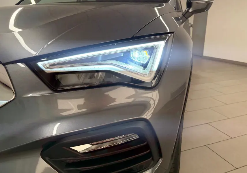 Gros plan sur le phare avant droit allumé du SEAT Ateca 2.0 TDI 150 DSG7 COPA gris graphite 2025.