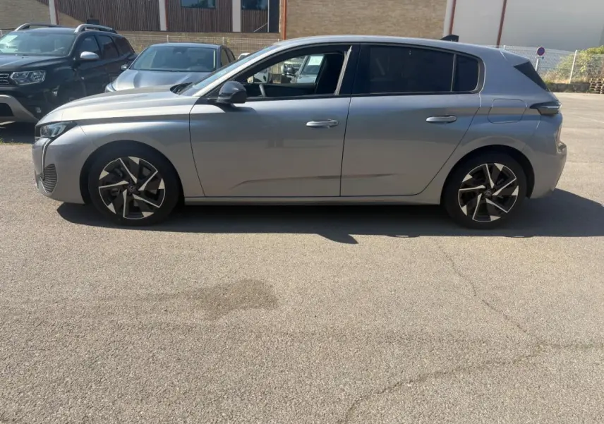 Peugeot 308 PHEV 180 e-EAT8 Allure gris clair vue de profil côté gauche, avec jantes alliage distinctives.