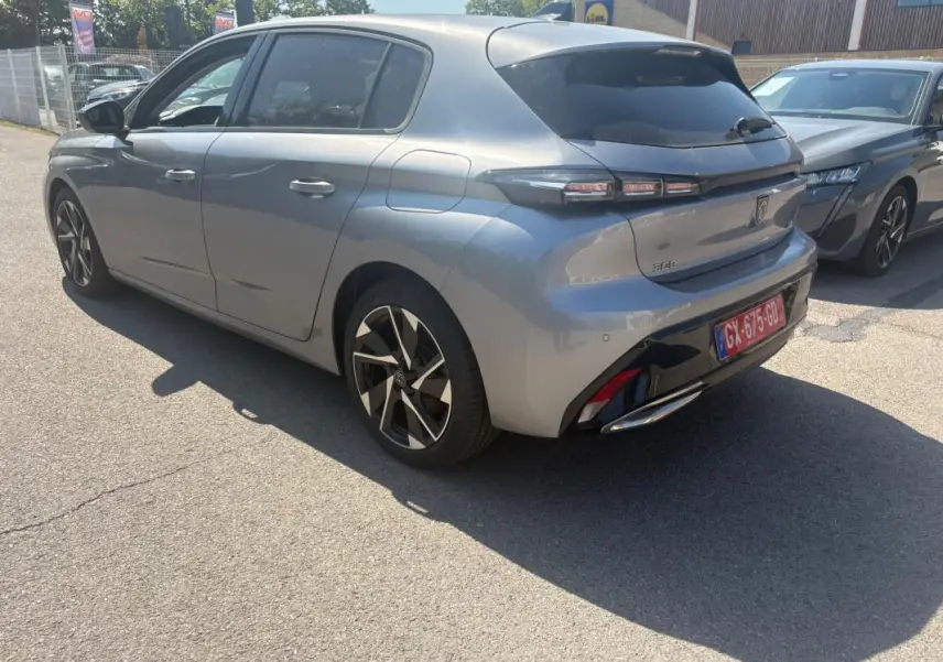 PEUGEOT 308 PHEV 180 e-EAT8 Allure gris clair vue 3/4 arrière droit avec jantes noires et détails noirs brillants.