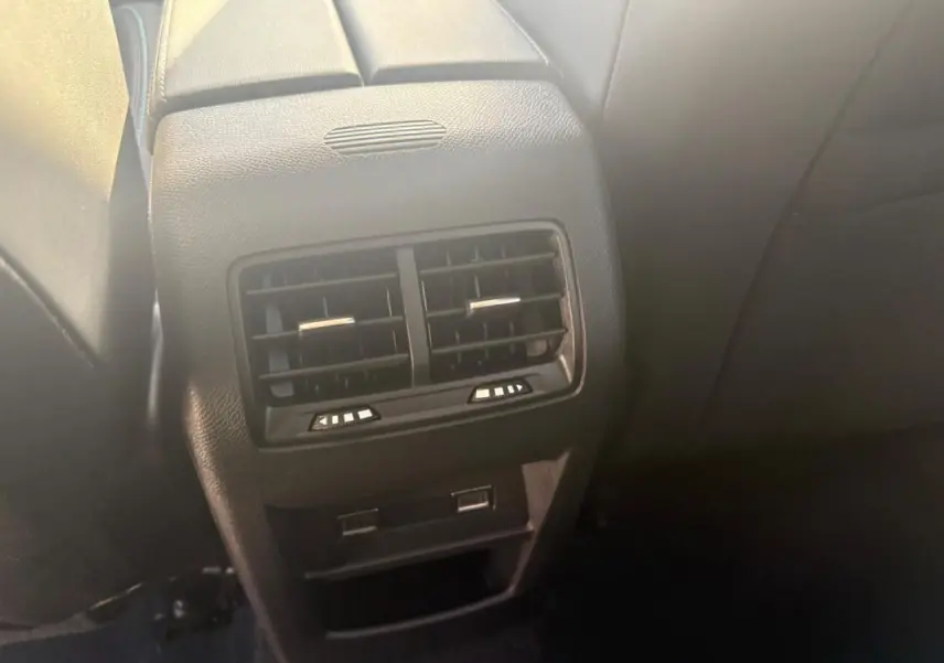 Gros plan sur la console arrière avec bouches d’aération et ports USB du Peugeot 308 PHEV 180 e-EAT8 Allure gris clair 2024.