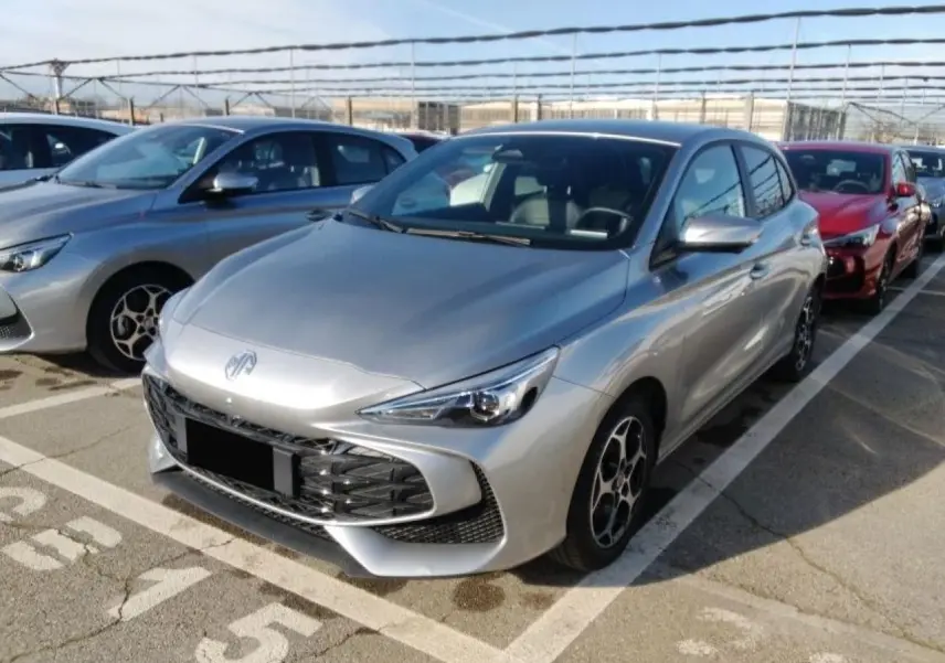 MG3 1.5 Hybrid+ 195 Luxury argent Cosmic en 3/4 avant droit, avec calandre large et jantes alliage 16 pouces.