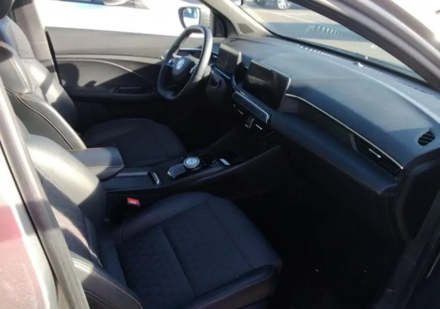 Vue intérieure côté conducteur du MG3 1.5 Hybrid+ 195 Luxury avec sellerie tissu/similicuir noir et écran tactile central.