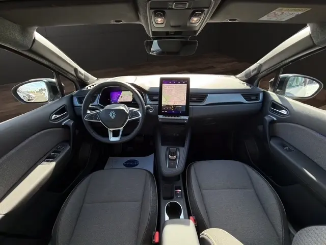 Vue intérieure avant du Renault Symbioz gris clair 2025, avec tableau de bord numérique et écran tactile central vertical.