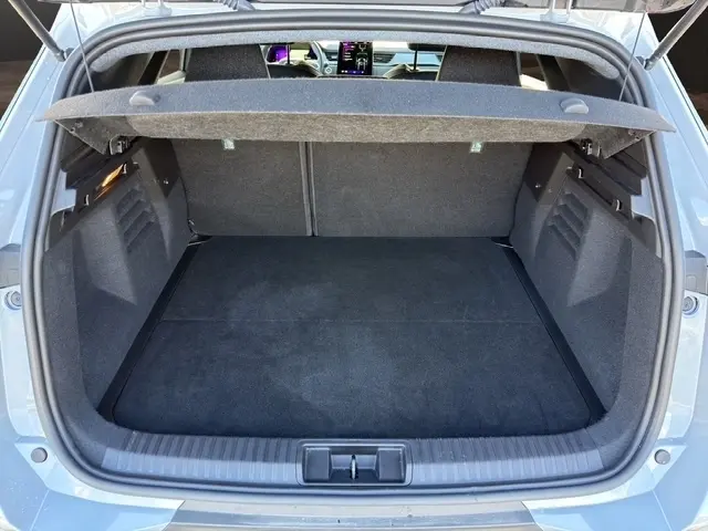 Coffre ouvert vu de l'arrière d'une Renault Symbioz gris clair, intérieur spacieux avec tablette de séparation visible.