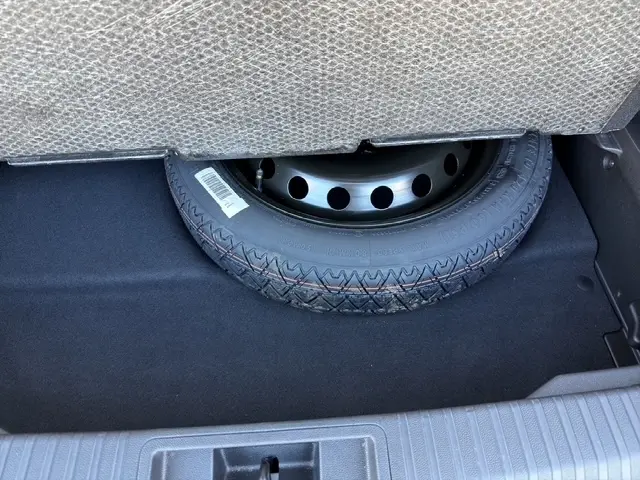 Gros plan sur la roue de secours sous le plancher du coffre du Renault Symbioz gris clair 2025.