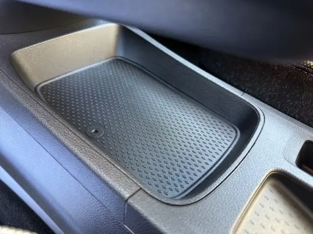 Gros plan sur le compartiment de rangement central noir du Renault Symbioz gris clair, version techno E-Tech full hybrid 160.