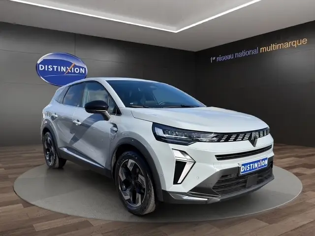 Renault Symbioz gris clair en 3/4 avant droit, avec calandre moderne et phares LED distinctifs.