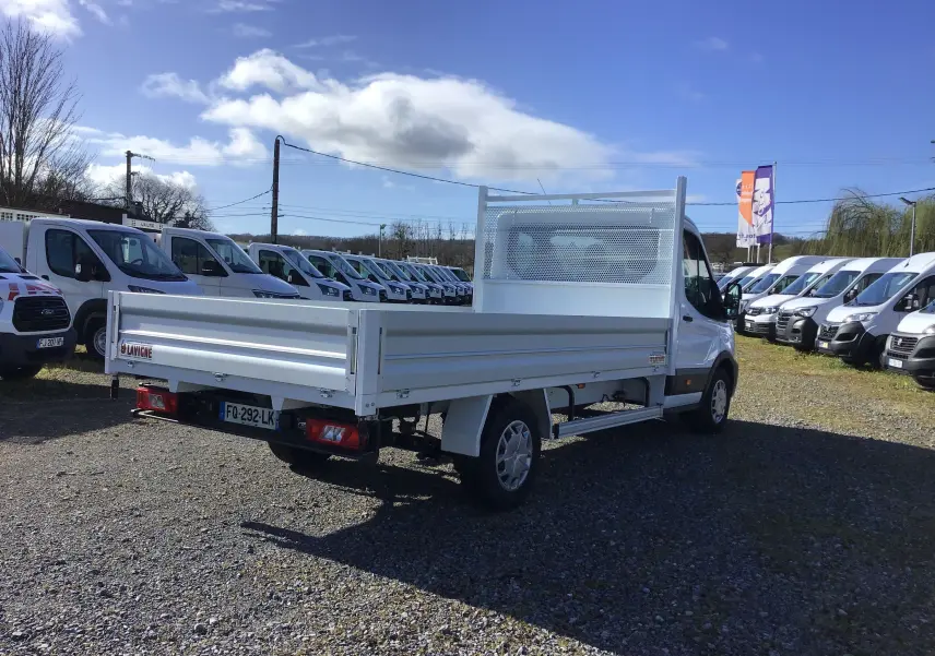 Ford Transit Chassis Cabine blanc vu en 3/4 arrière droit, avec plateau 4 mètres et ridelles en aluminium.