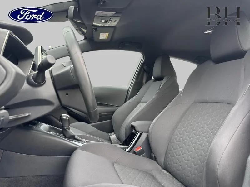 Vue intérieure côté conducteur de la Toyota Corolla 122h Dynamic Business 2020 avec sièges tissu noir et volant cuir multifonction