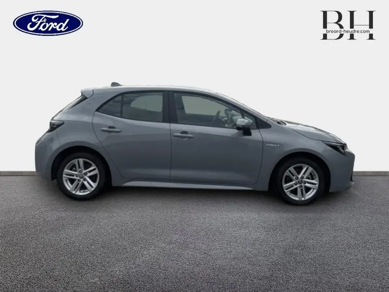 Profil côté gauche d'une Toyota Corolla 122h Dynamic Business 2020 en gris Manhattan métallisé avec jantes alu et feux LED.