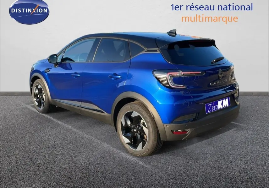Vue 3/4 arrière droite d'un Renault Captur E-Tech hybride 2025 bleu Iron Metal avec toit noir et jantes noires biton.