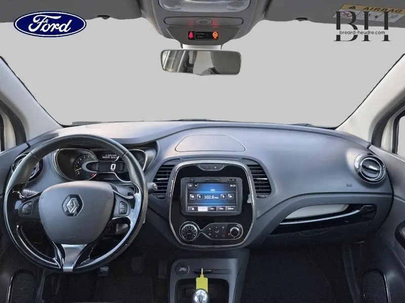 Vue intérieure du tableau de bord du Renault Captur 2015 avec volant cuir et écran tactile central.