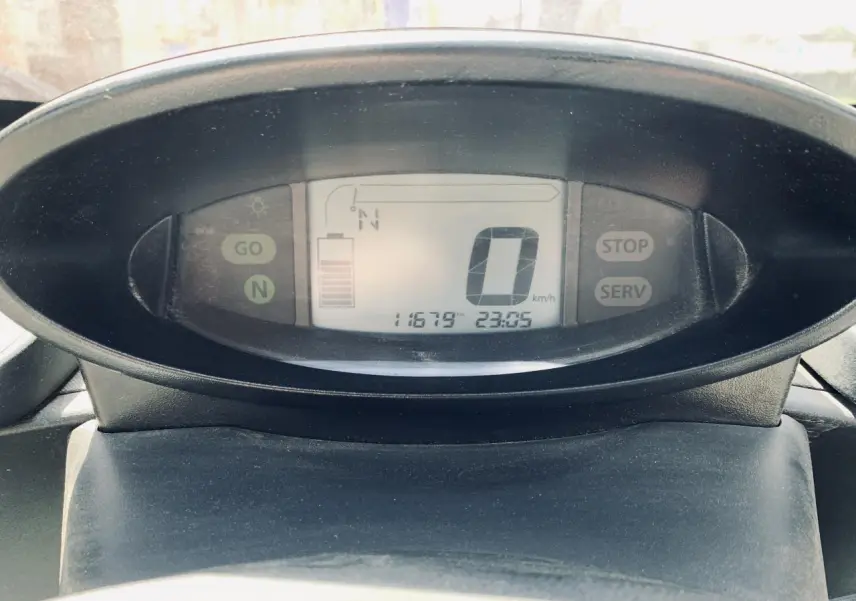 Vue rapprochée du tableau de bord numérique de la Renault Twizy blanc, affichant vitesse et niveau de batterie.