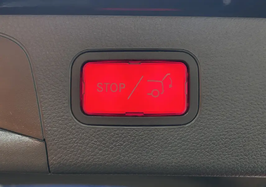 Bouton rouge d'arrêt d'ouverture/fermeture électrique du hayon sur Mercedes GLC noir Obsidienne AMG Line, vue intérieure.