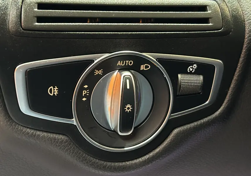 Gros plan sur le sélecteur de phares noir et chrome du Mercedes GLC 220D AMG Line 2021, avec commande d'éclairage automatique.