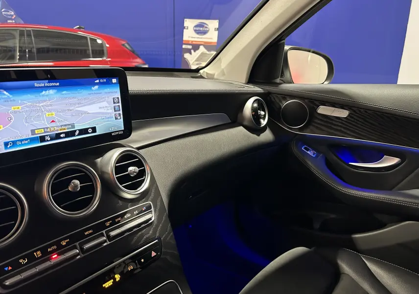Vue intérieure côté passager du Mercedes GLC 220D AMG Line 2021, avec tableau de bord noir et éclairage d'ambiance bleu.
