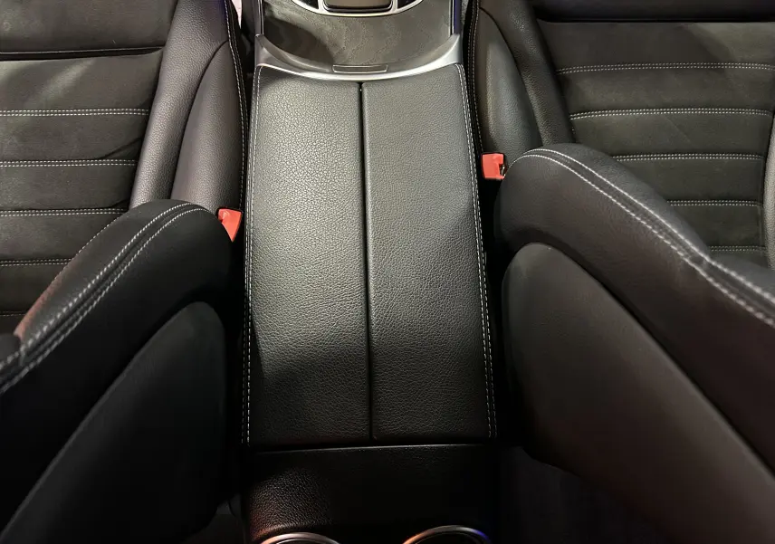 Vue plongeante sur la console centrale en cuir noir avec surpiqûres blanches du Mercedes GLC 220D AMG Line 2021.