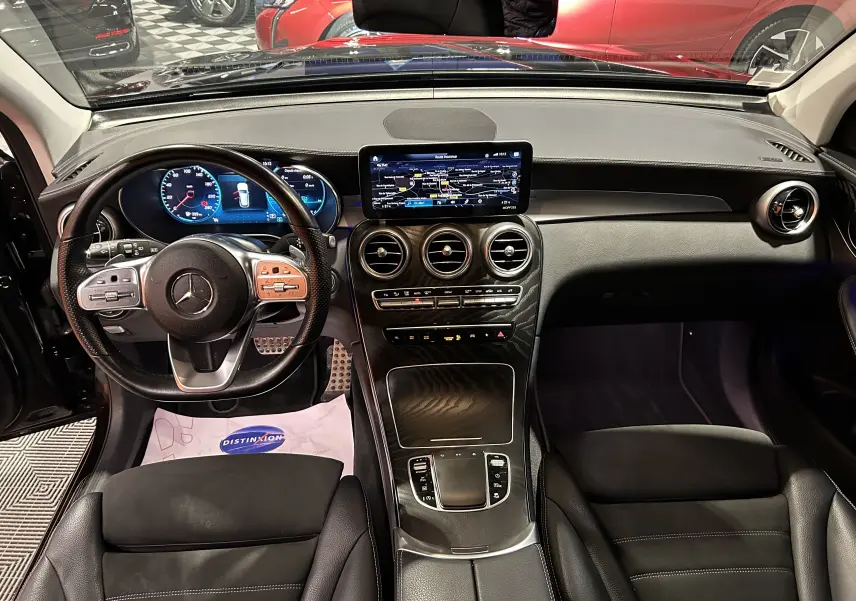 Vue intérieure avant du Mercedes GLC 220D AMG Line 2021, tableau de bord et volant cuir noir avec écran central tactile.